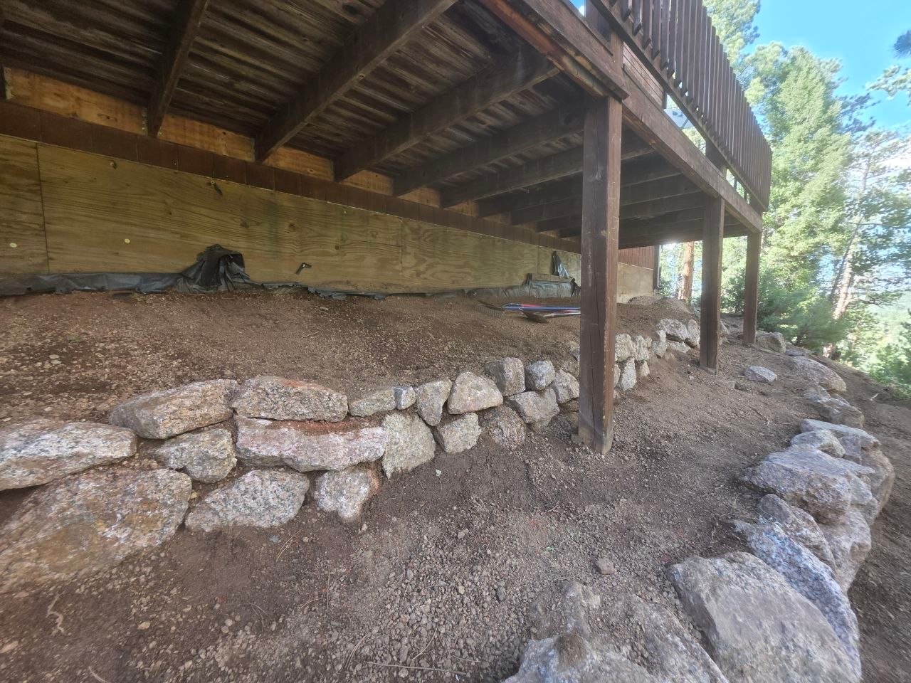 Boulder wall parallel to foundation under deck, Woodland Park CO — Oakden Enterprises