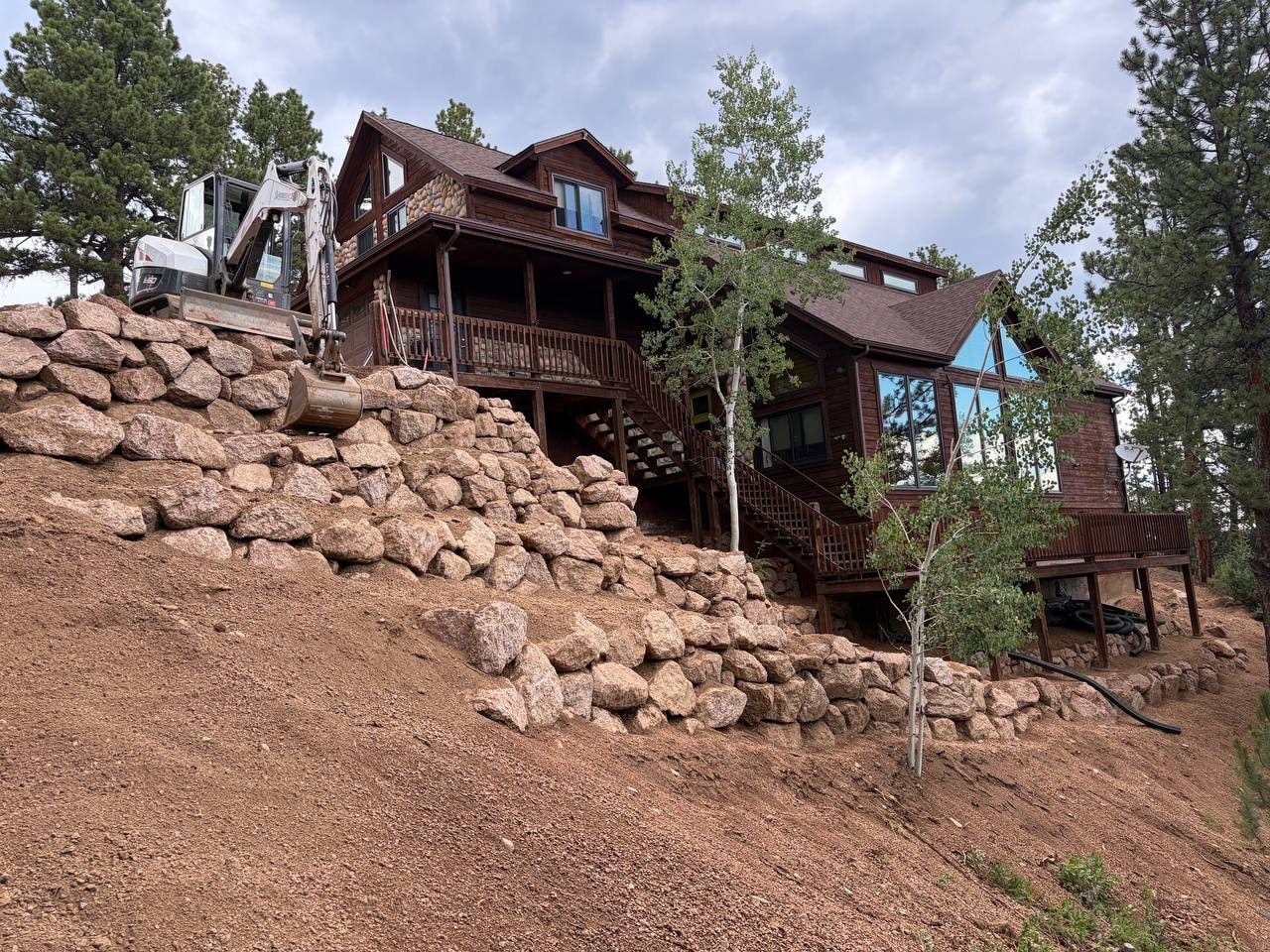 Boulder wall under construction with gravel base detail, Woodland Park CO — Oakden Enterprises